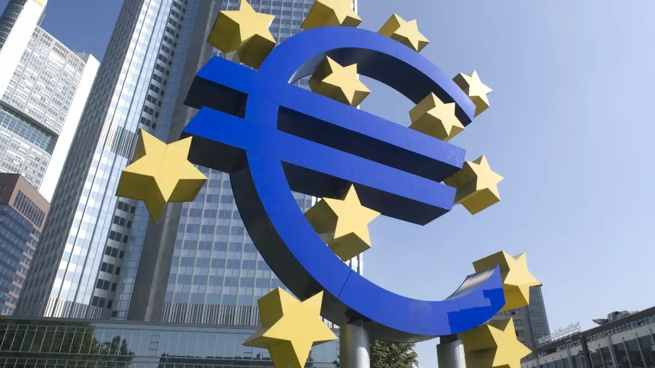 Simbolo dell'Euro con stelle gialle davanti a grattacieli moderni, evocando la stabilità della politica fiscale europea.