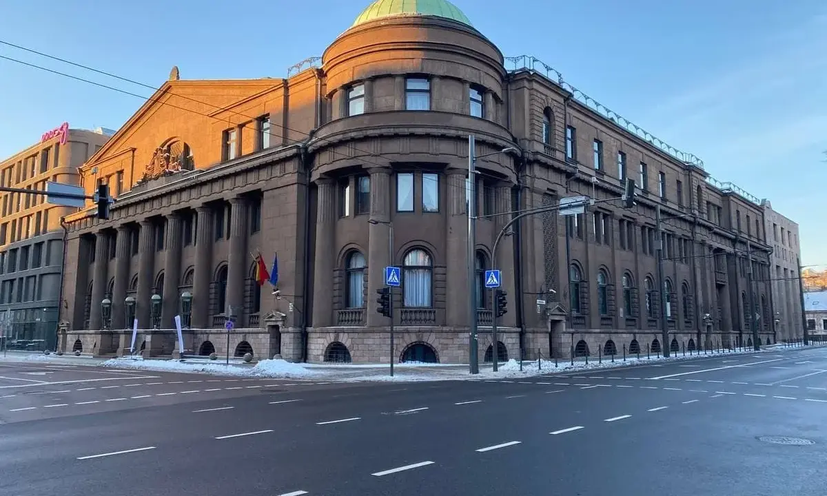 Edificio imponente con colonne, cupola verde e bandiere lituane. Il **bank of Lithuania** si erge maestoso sotto un cielo azzurro.