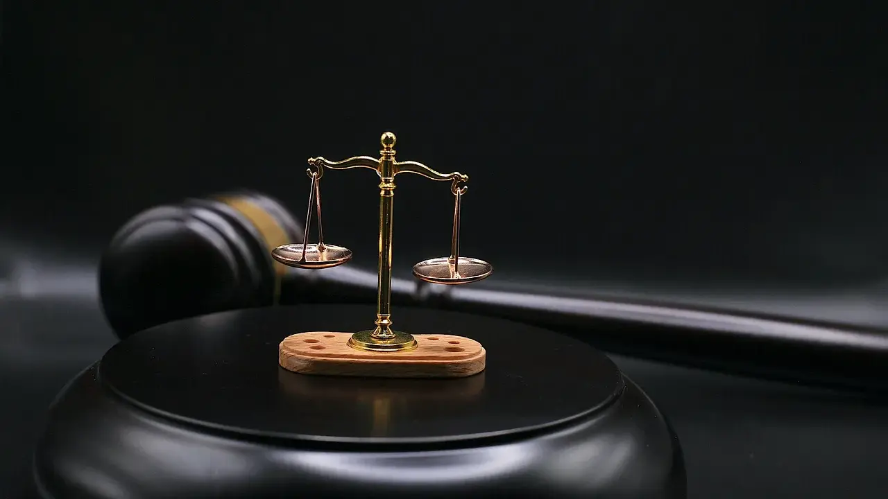 Bilancia della giustizia e martello del giudice su sfondo scuro. Il **ricusazione significato** è un concetto chiave nel diritto.