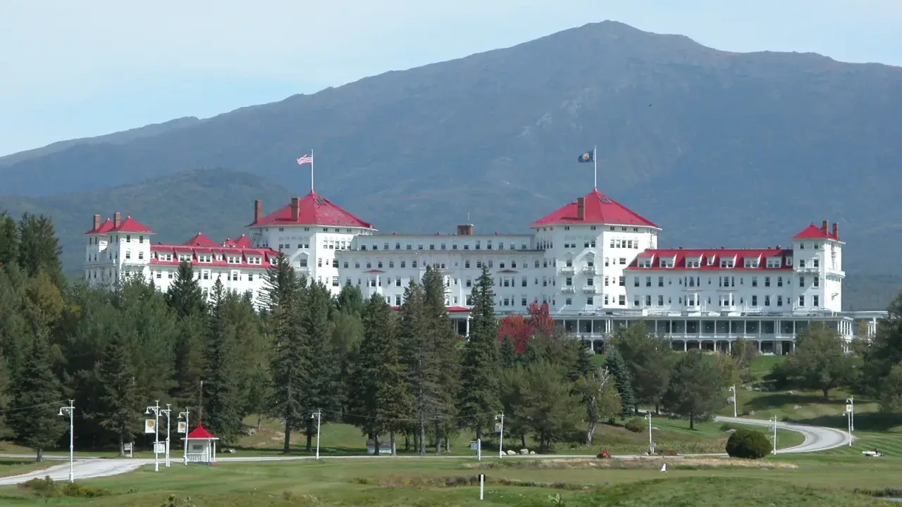 The Omni Mount Washington Resort with red roofs and a mountain in the background.