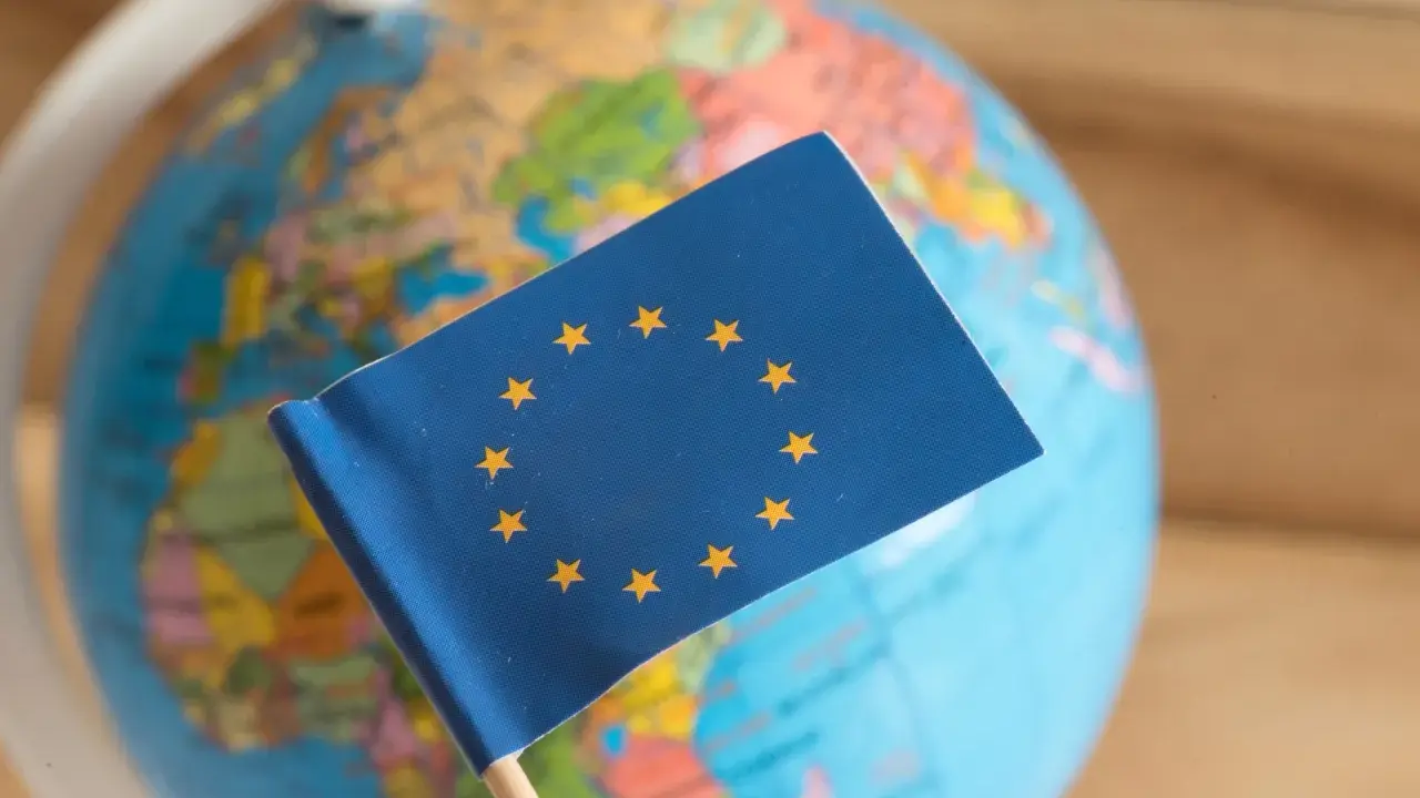 Bandiera UE su globo terrestre. Un simbolo di unione, ma che cos'è il protezionismo?