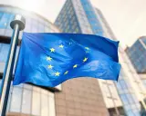 Bandiera europea sventola davanti a edifici moderni, simbolo di unità e di un futuro con un **grant significato economia** per il continente.