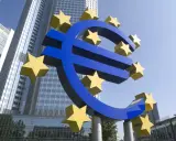 Simbolo dell'Euro con stelle gialle davanti a grattacieli moderni, evocando la stabilità della politica fiscale europea.
