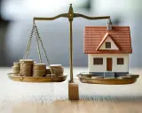 Bilancia con monete e casa in miniatura, un'immagine che evoca le decisioni economiche della banca centrale europea.
