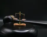 Bilancia della giustizia e martello del giudice su sfondo scuro. Il **ricusazione significato** è un concetto chiave nel diritto.
