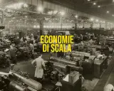Operai in una grande fabbrica lavorano a macchine utensili, un esempio di economie di scala nella produzione industriale.