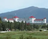 The Omni Mount Washington Resort with red roofs and a mountain in the background.