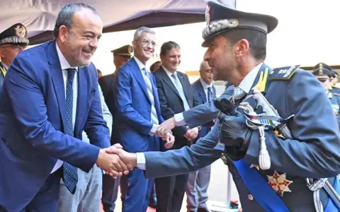 Mariano La Malfa stringe la mano a un ufficiale in alta uniforme, in un momento di saluto ufficiale.