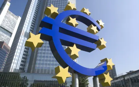 Simbolo dell'Euro con stelle gialle davanti a grattacieli moderni, evocando la stabilità della politica fiscale europea.