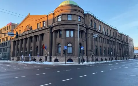 Edificio imponente con colonne, cupola verde e bandiere lituane. Il **bank of Lithuania** si erge maestoso sotto un cielo azzurro.