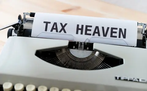 Macchina da scrivere con foglio che recita "TAX HEAVEN", evocando il concetto di paradisi fiscali.