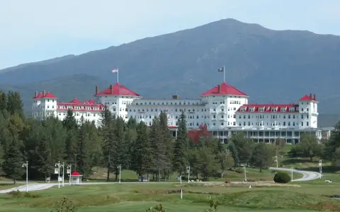 The Omni Mount Washington Resort with red roofs and a mountain in the background.