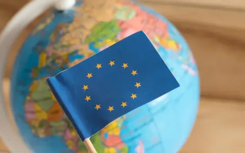 Bandiera UE su globo terrestre. Un simbolo di unione, ma che cos'è il protezionismo?