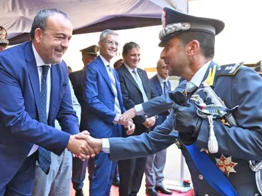 Mariano La Malfa stringe la mano a un ufficiale in alta uniforme, in un momento di saluto ufficiale.