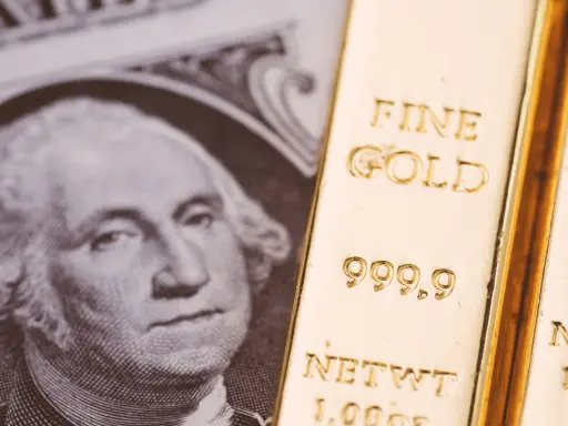 Lingotto d'oro accanto a un dollaro, evocando il gold standard significato.