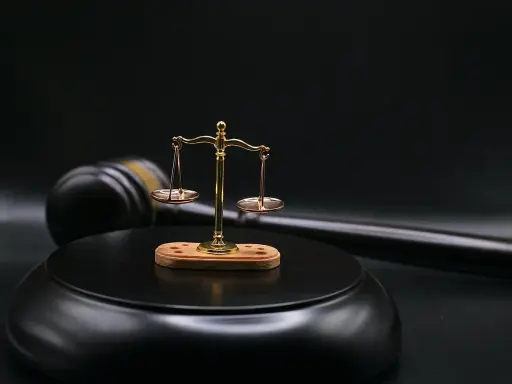 Bilancia della giustizia e martello del giudice su sfondo scuro. Il **ricusazione significato** è un concetto chiave nel diritto.