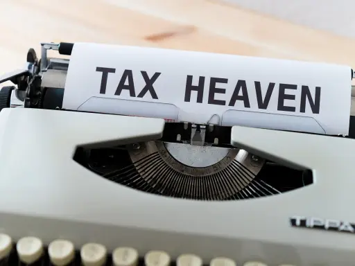 Macchina da scrivere con foglio che recita "TAX HEAVEN", evocando il concetto di paradisi fiscali.