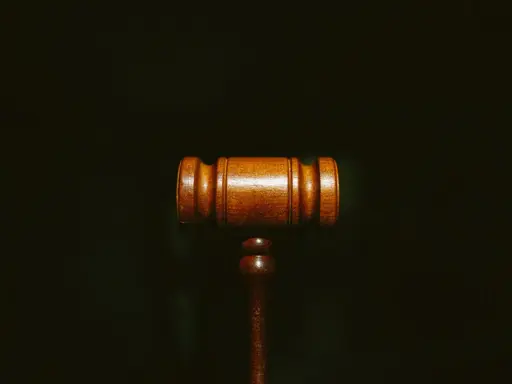 Martelletto da giudice in legno scuro, simbolo di giustizia e del convenuto significato.