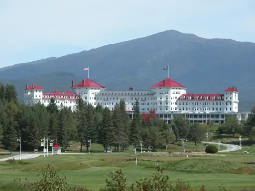 The Omni Mount Washington Resort with red roofs and a mountain in the background.