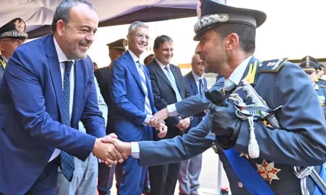 Mariano La Malfa stringe la mano a un ufficiale in alta uniforme, in un momento di saluto ufficiale.
