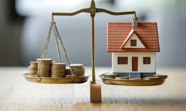 Bilancia con monete e casa in miniatura, un'immagine che evoca le decisioni economiche della banca centrale europea.