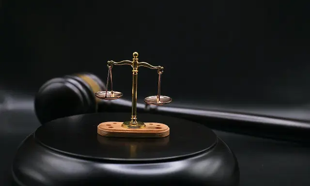 Bilancia della giustizia e martello del giudice su sfondo scuro. Il **ricusazione significato** è un concetto chiave nel diritto.