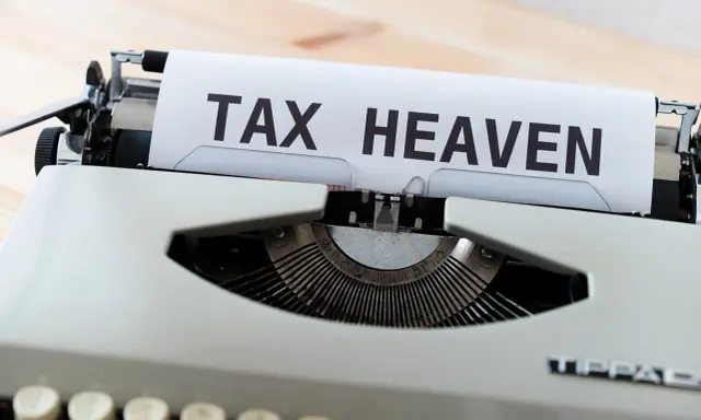 Macchina da scrivere con foglio che recita "TAX HEAVEN", evocando il concetto di paradisi fiscali.