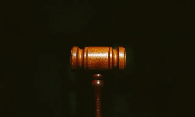 Martelletto da giudice in legno scuro, simbolo di giustizia e del convenuto significato.