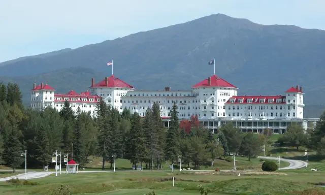The Omni Mount Washington Resort with red roofs and a mountain in the background.