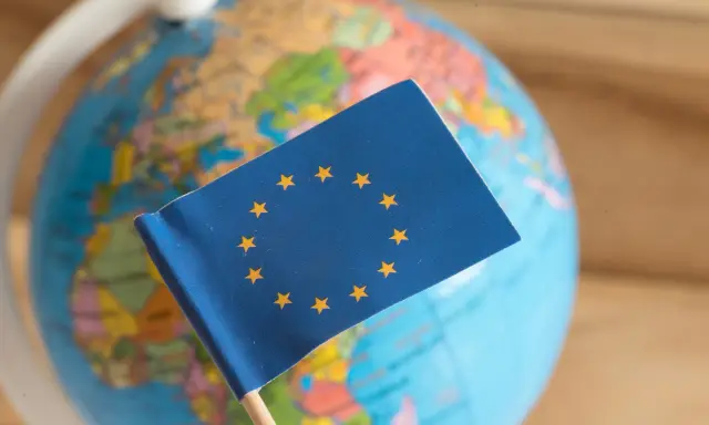 Bandiera UE su globo terrestre. Un simbolo di unione, ma che cos'è il protezionismo?