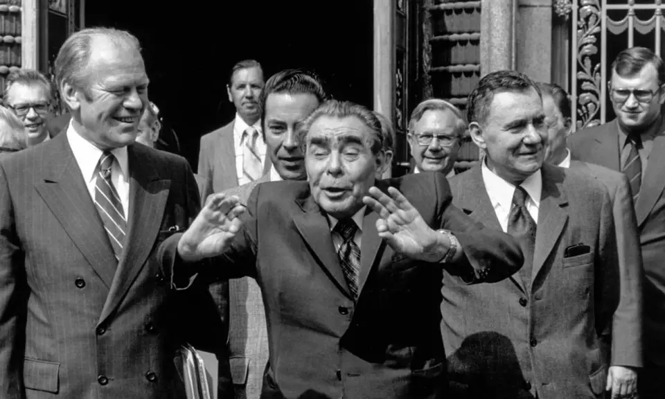 Leader sovietico Leonid Breznev, con le mani alzate, durante l'atto finale di Helsinki. Accanto a lui, Gerald Ford sorride.