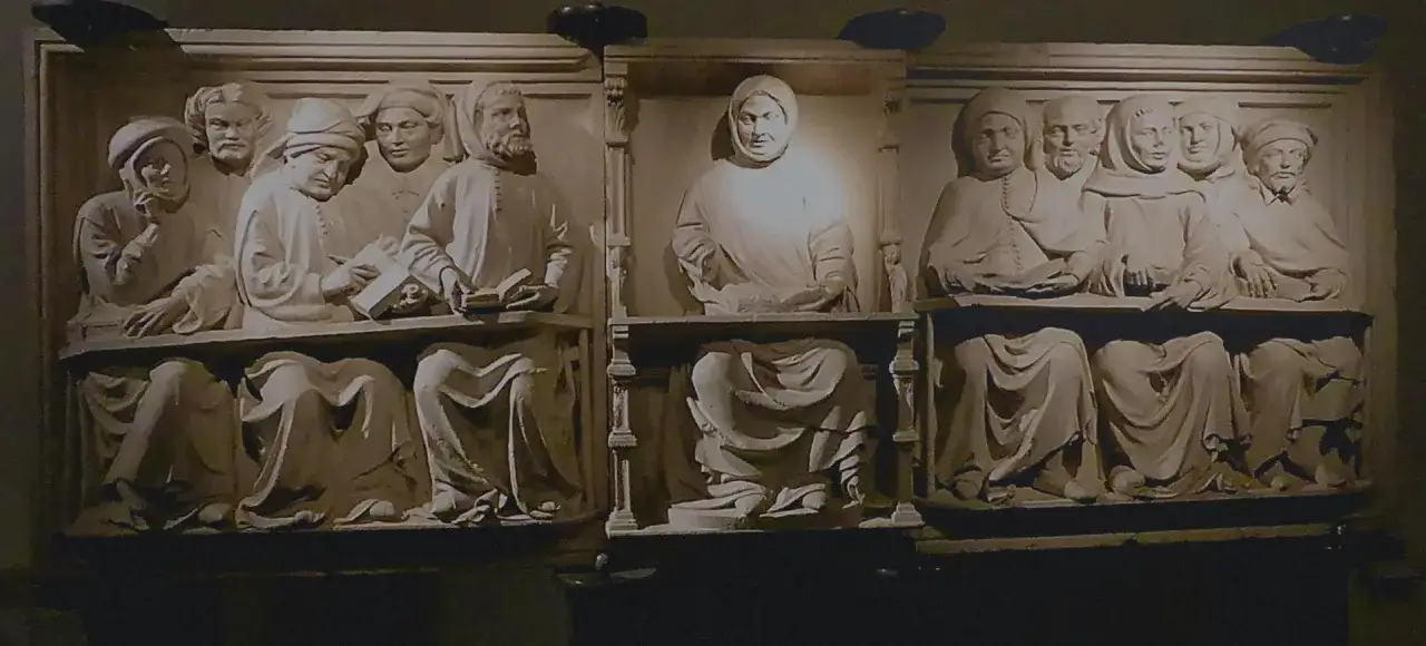 Scultura raffigurante un gruppo di studiosi seduti, intenti nella lettura e discussione, che evocano elementi di storia del diritto europeo.