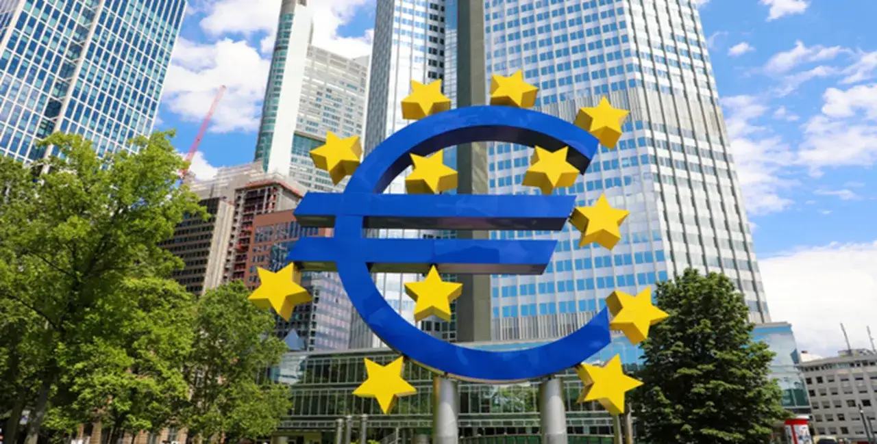 Simbolo dell'euro con stelle gialle davanti a grattacieli moderni, vicino alla banca centrale olandese.