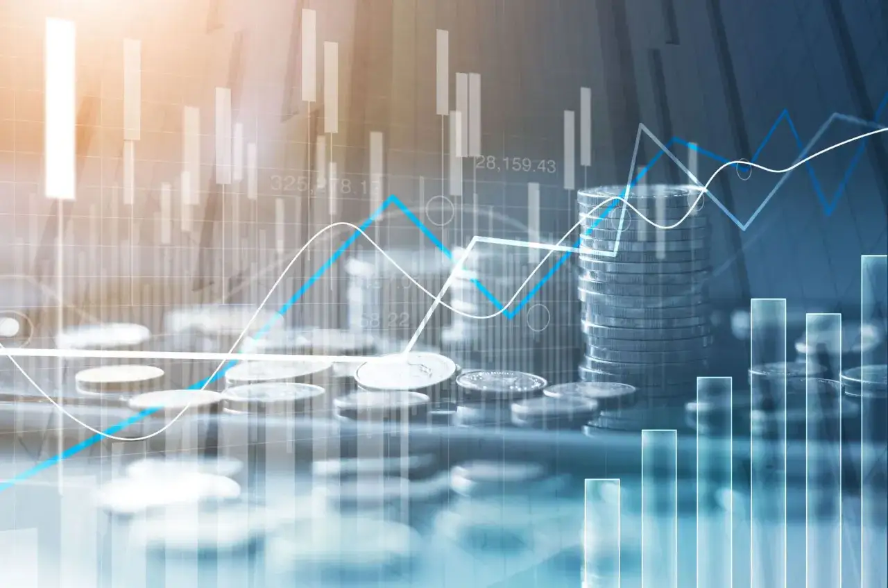 Grafici finanziari sovrapposti a pile di monete, che illustrano il concetto di aggiotaggio significato e la volatilità del mercato.