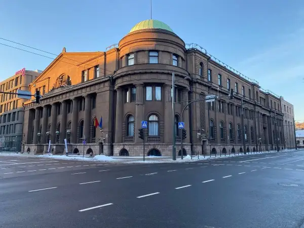Edificio imponente con colonne, cupola verde e bandiere lituane. Il **bank of Lithuania** si erge maestoso sotto un cielo azzurro.